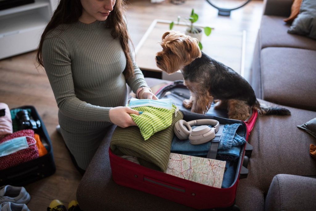 En man gör sig redo att gå, medan en hund tittar på honom.