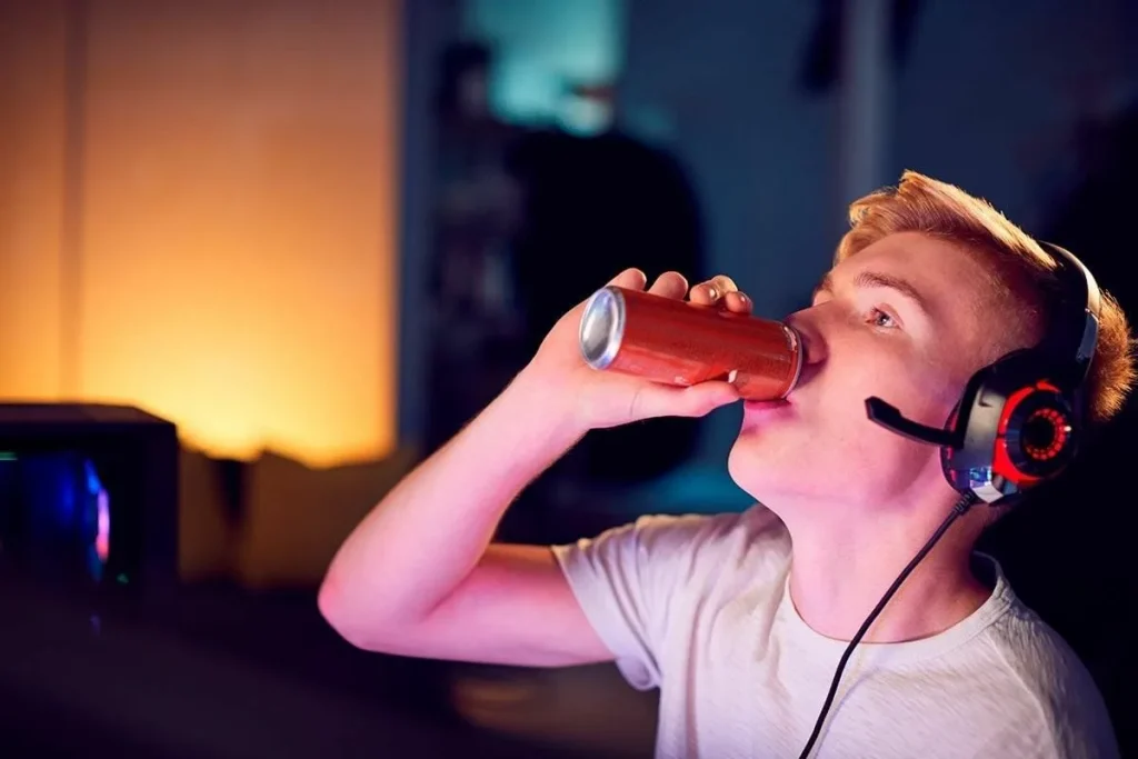 Tonåringen dricker en energidryck.