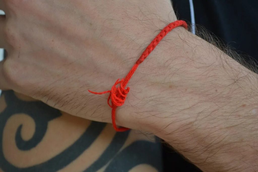 Det röda bandet ska bäras på vänster arm.