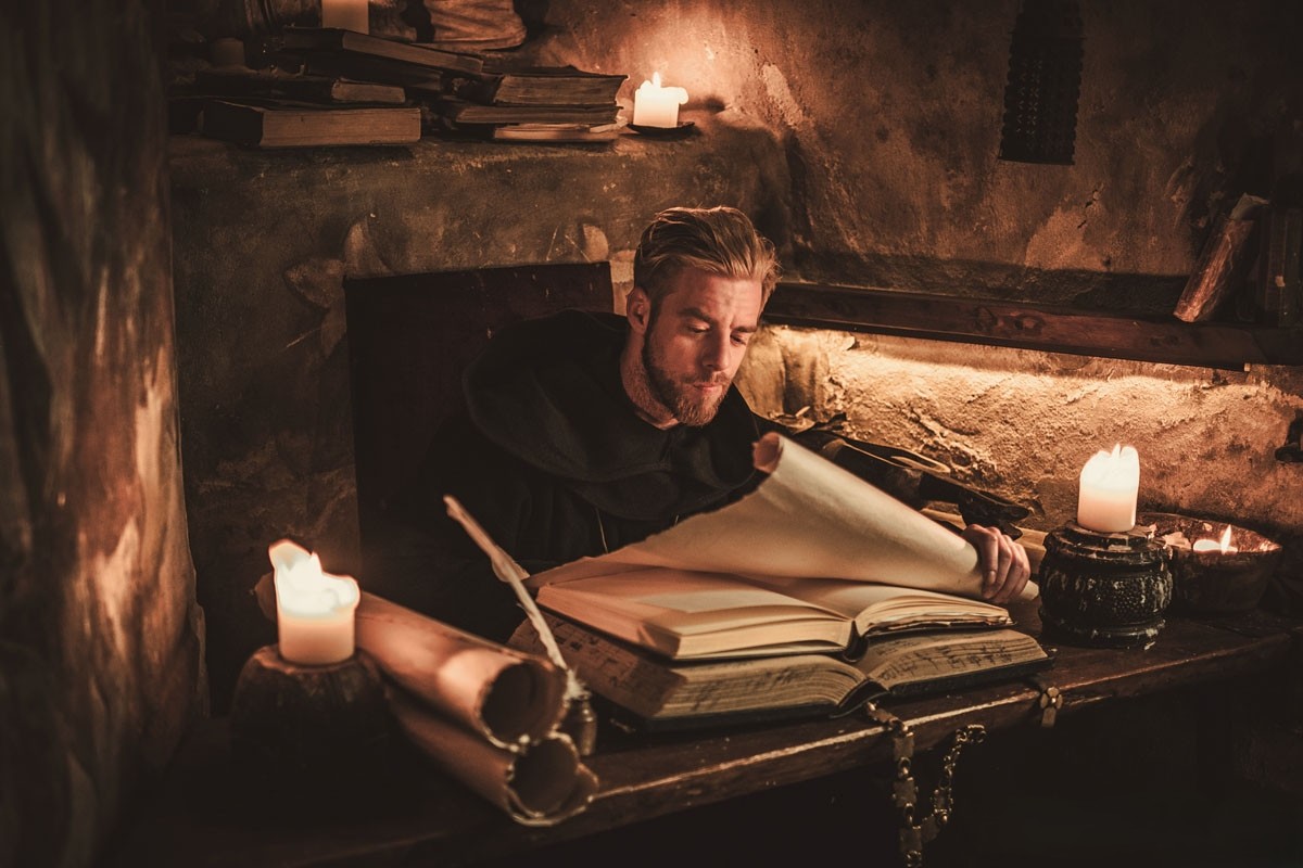 Munken skriver sina ord på pergament.