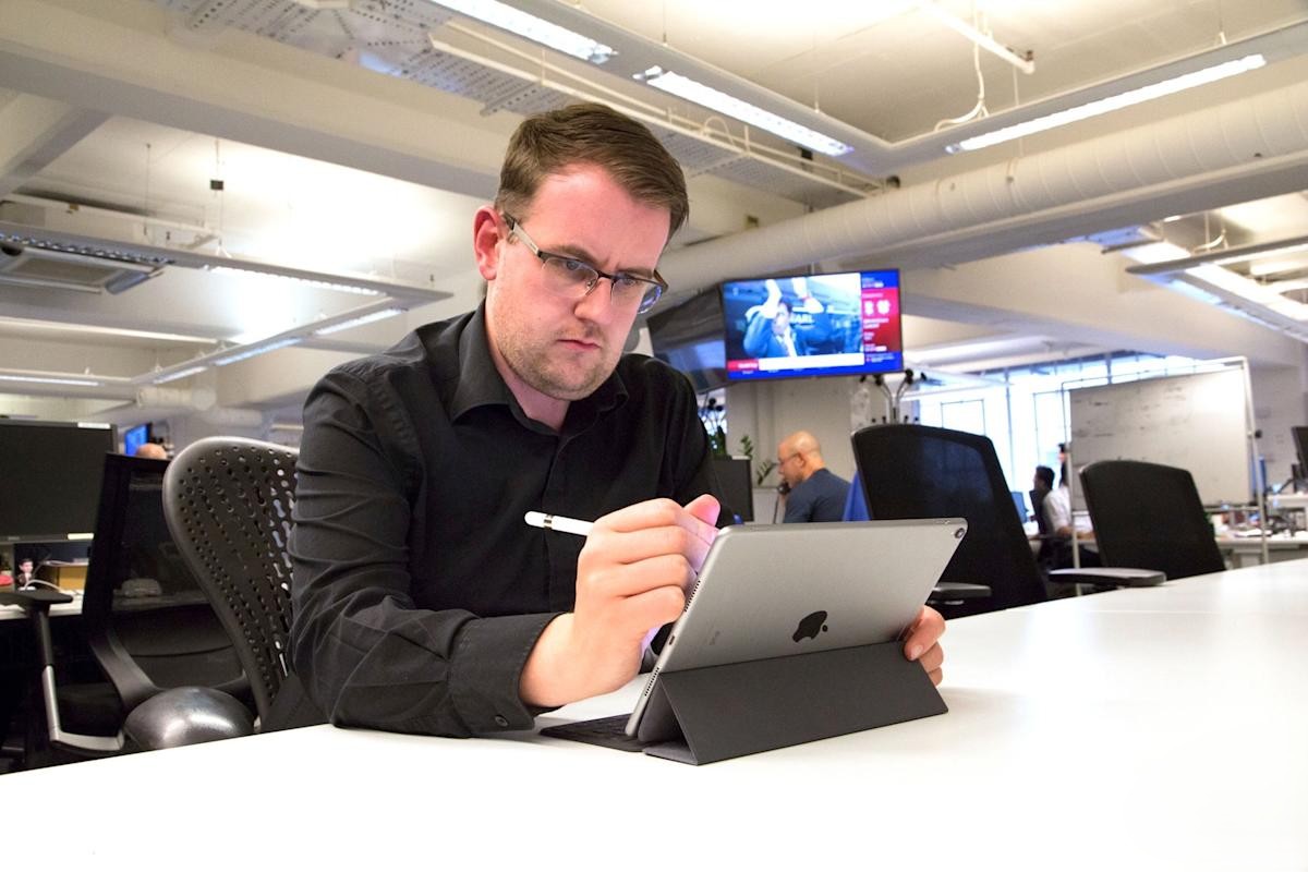 Mannen arbetar på en iPad Air.