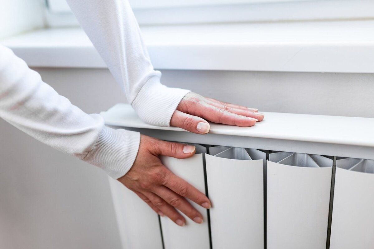 En kvinna håller fast i Radiator med händerna.