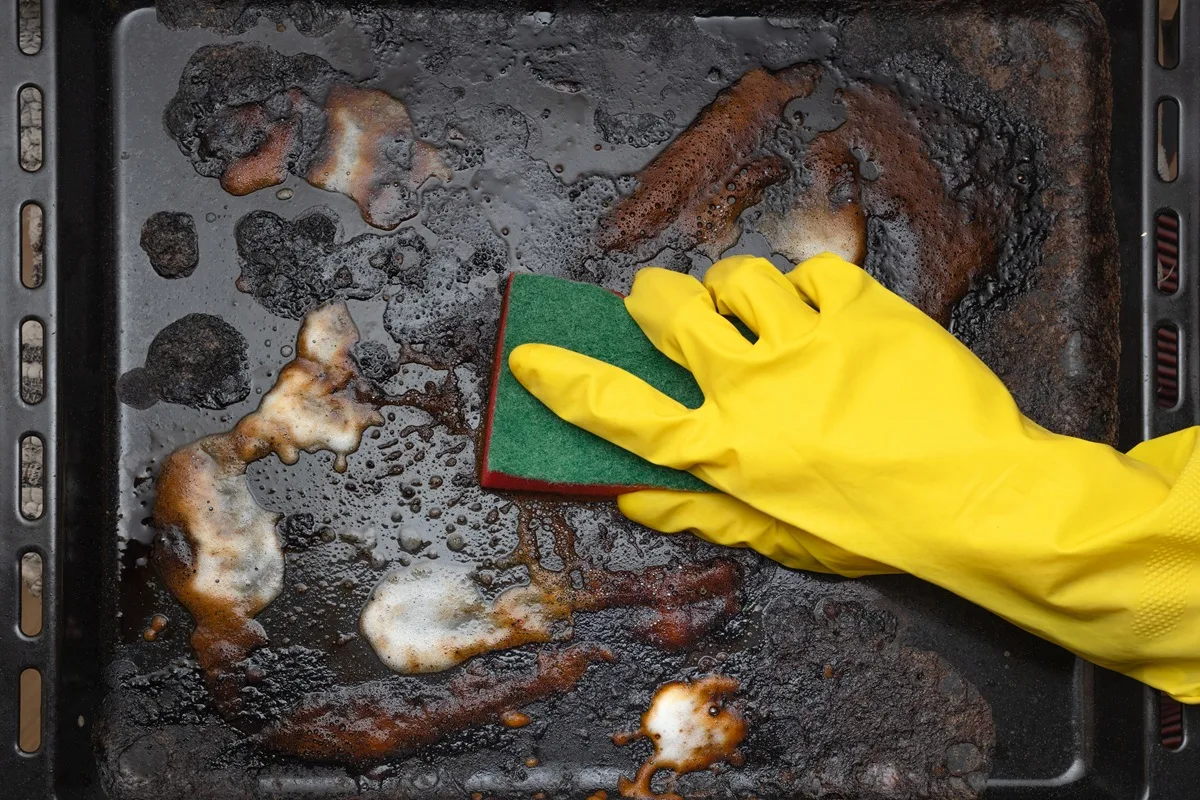 Rengöring av en smutsig bakplåt.