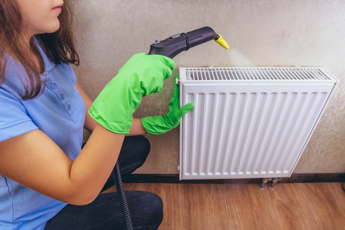 Flickan tvättar radiator.