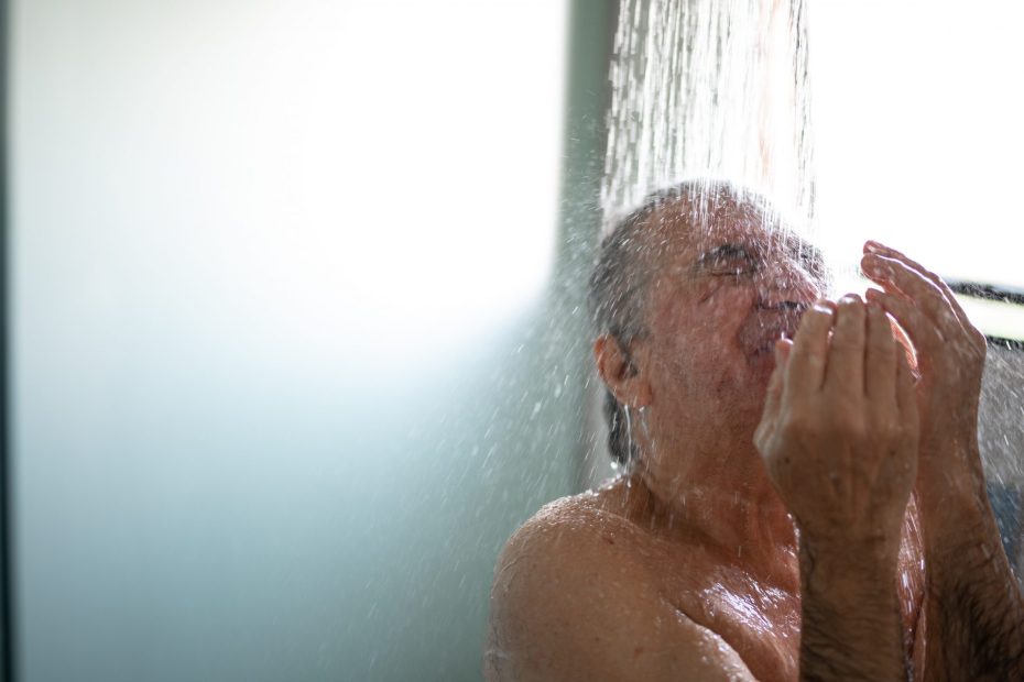 En äldre man tar en dusch.