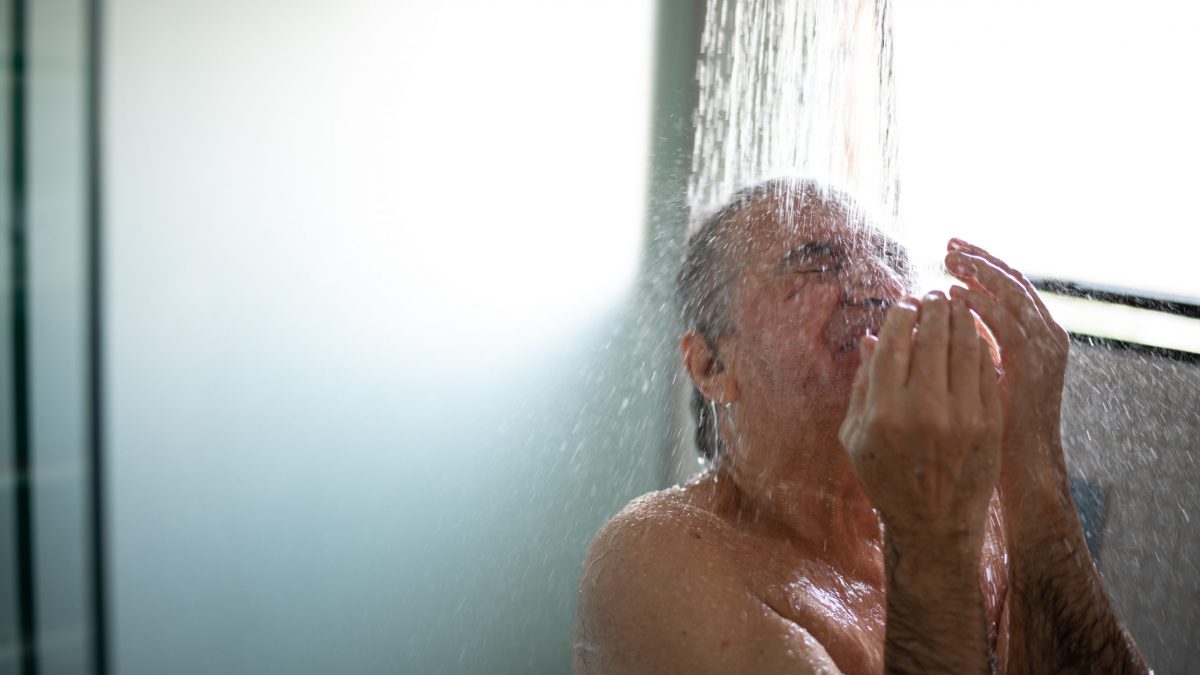 En äldre man tar en dusch.