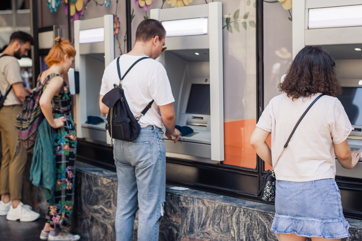 Människor genomför transaktioner vid bankomater.