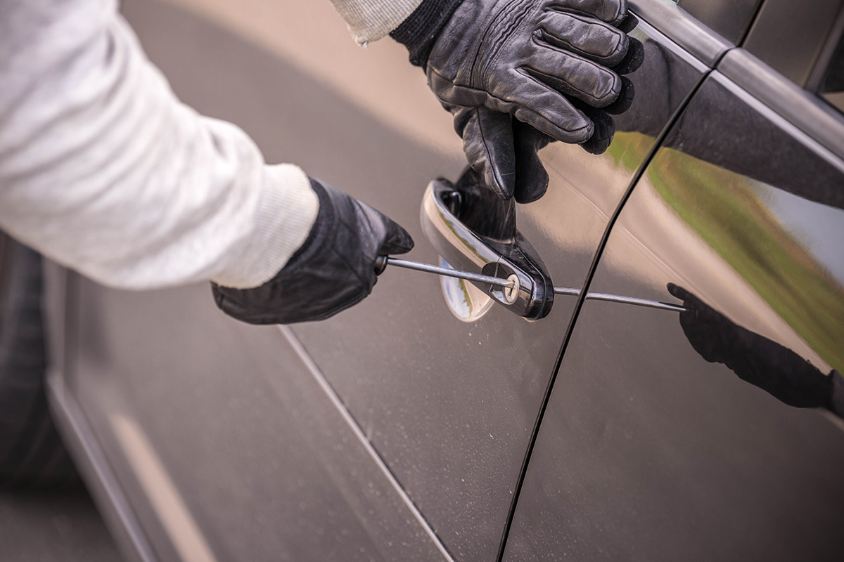 Tjuven försöker bryta sig in i bildörren.