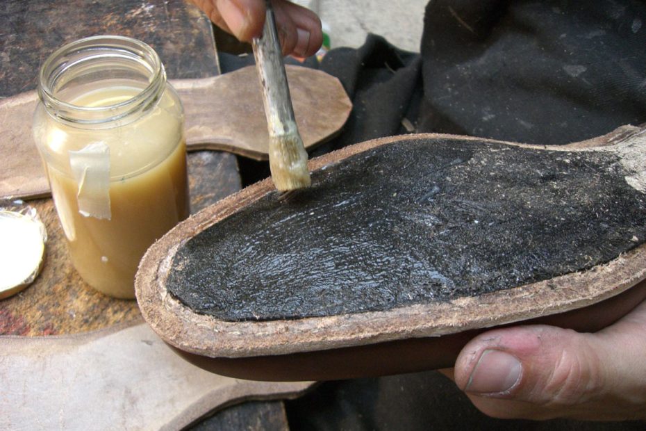 Skomakaren limmar fast sulan på skon skosulorna.