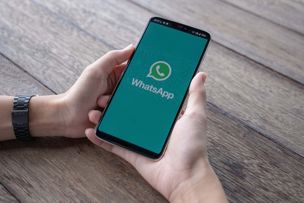 En person håller en smartphone med WhatsApp-applikationen öppen.