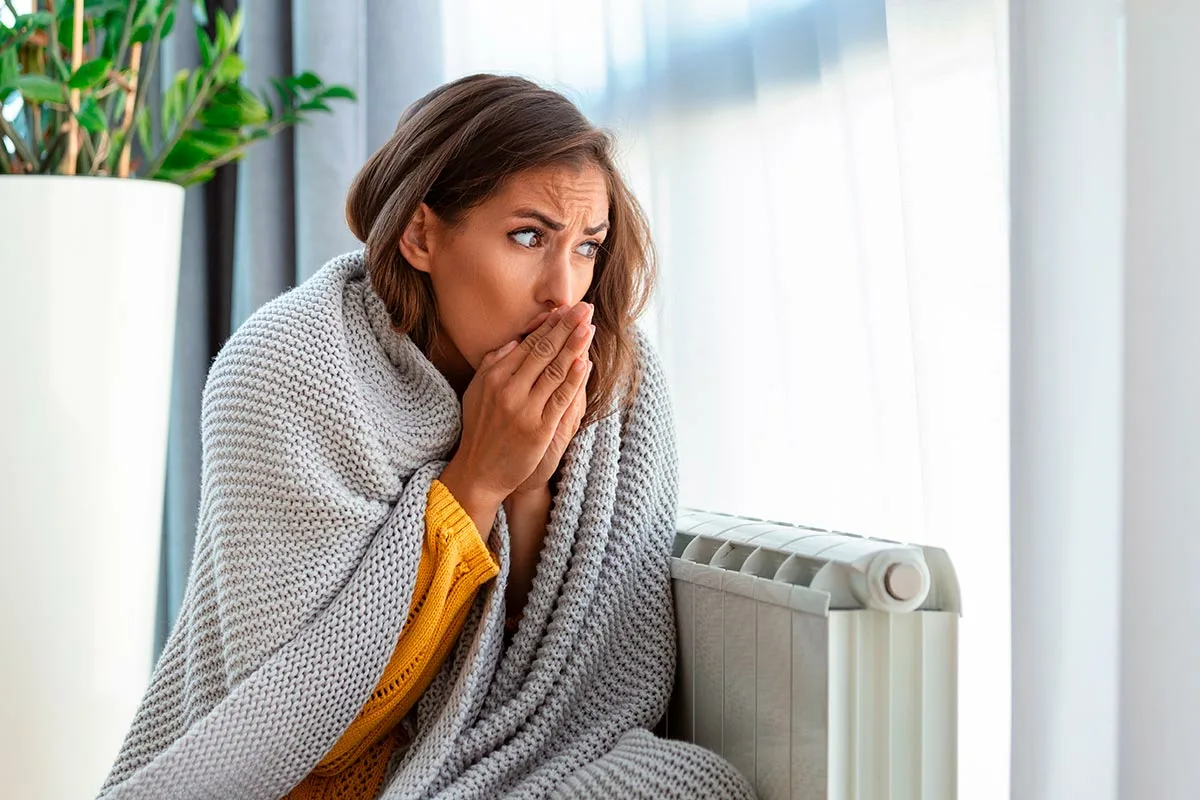 Flickan fryser vid elementet.