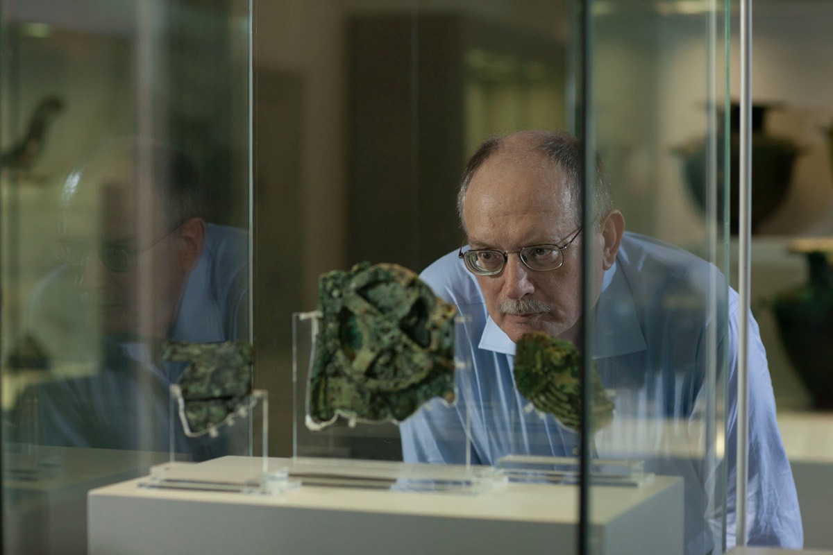 En man betraktar denna mekanism från den antika världen med stor uppmärksamhet.