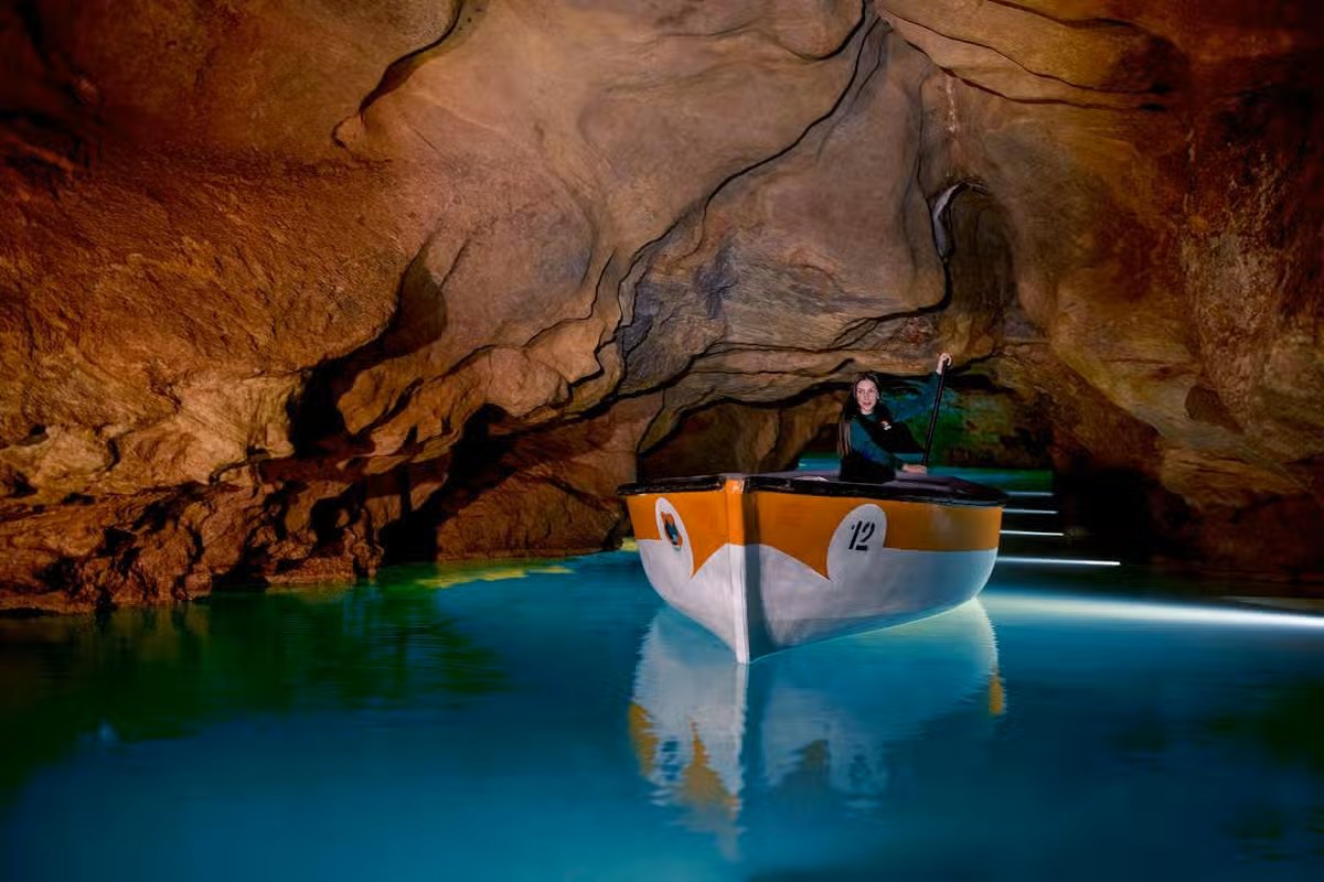 En flicka flyter nedför en underjordisk flod.