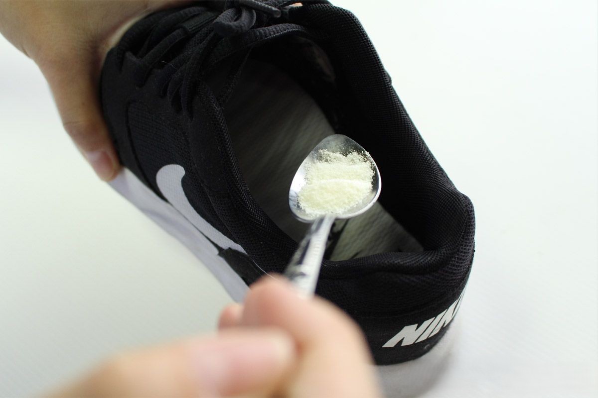 En man strör bakpulver i sina skor.