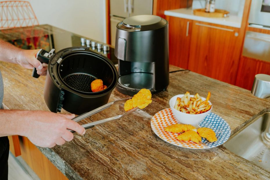 En person använder en luftfritös för att tillaga mat.