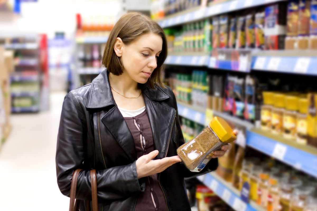 En flicka väljer kaffe i en stormarknad.